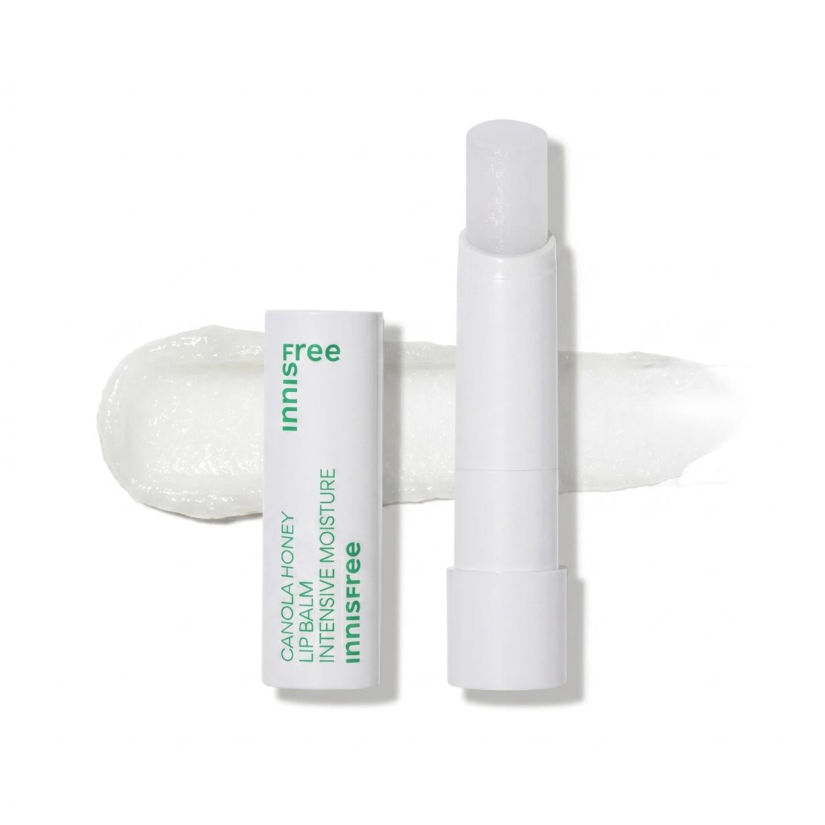 An open white tube of InnFree Canola Honey Intensive Moisture Lip Balm stands next to its matching white packaging sleeve, with a white lip balm smear displayed behind them on a clean white background.